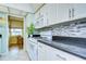 White kitchen with granite countertops and mosaic backsplash at 1893 Shore S Dr # 206, South Pasadena, FL 33707