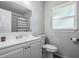 Updated bathroom with white vanity, toilet and shower at 345 Country Club Dr, Oldsmar, FL 34677