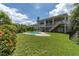 The expansive backyard offers lush green grass, mature trees, and secure fencing, providing privacy and space at 435 Westwinds Drive, Palm Harbor, FL 34683