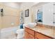 Bathroom with a tub, marble vanity, sink, and toilet with tropical themed shower curtain and decor at 435 Westwinds Drive, Palm Harbor, FL 34683