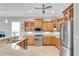Well-lit kitchen featuring wooden cabinets, granite countertops, stainless steel appliances, and a breakfast bar at 435 Westwinds Drive, Palm Harbor, FL 34683