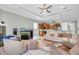 Open-concept living room with plush furniture, ceiling fan, fireplace, and a bar area near the kitchen at 435 Westwinds Drive, Palm Harbor, FL 34683