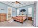 Comfortable bedroom with blue walls, crown molding, carpet floors, fan, and an en-suite bathroom at 435 Westwinds Drive, Palm Harbor, FL 34683