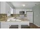 Modern kitchen with white cabinets, granite countertops, and stainless steel appliances at 7030 Lafayette N, Pinellas Park, FL 33781