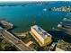 Aerial view of waterfront building with boat slips and city skyline in background at 100 Bluff View Dr # 405C, Belleair Bluffs, FL 33770