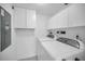 Laundry room with washer, dryer, cabinets, and utility sink at 3021 Countryside Blvd # 28A, Clearwater, FL 33761