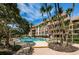Community pool with surrounding patio and tropical landscaping at 3021 Countryside Blvd # 28A, Clearwater, FL 33761
