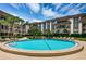 Circular swimming pool surrounded by lounge chairs and landscaping at 3021 Countryside Blvd # 28A, Clearwater, FL 33761