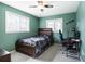 Bedroom with teal walls, ceiling fan, and gaming setup at 3047 Enisglen Dr, Palm Harbor, FL 34683