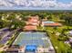 Expansive aerial view of the community showcasing tennis courts, a pool, clubhouse, and lush landscaping at 3332 Mcmath Dr, Palm Harbor, FL 34684