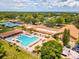 Stunning aerial view of a community pool, tennis courts, and lush landscaping offering a resort-style living experience at 3332 Mcmath Dr, Palm Harbor, FL 34684
