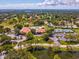 Gorgeous aerial showcasing golf course, pool, tennis courts and lakes in a beautiful community at 3332 Mcmath Dr, Palm Harbor, FL 34684