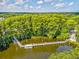Scenic aerial of the community dock, providing access to serene waters and natural beauty, with lush trees nearby at 3332 Mcmath Dr, Palm Harbor, FL 34684