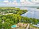 Gorgeous aerial view of a lakeside property highlighting the pool, clubhouse, and peaceful waterfront setting at 3332 Mcmath Dr, Palm Harbor, FL 34684