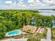 Breathtaking aerial view of a lakeside community featuring a pool, clubhouse, and serene natural surroundings at 3332 Mcmath Dr, Palm Harbor, FL 34684