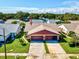 Aerial view of a residential property featuring a well-manicured lawn, driveway, and two-car garage at 3332 Mcmath Dr, Palm Harbor, FL 34684