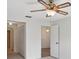 Bedroom featuring a ceiling fan, closet, and adjacent room with decorative light fixture at 3332 Mcmath Dr, Palm Harbor, FL 34684