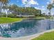 Beautiful Highland Lakes community entrance featuring a pond and lush landscaping at 3332 Mcmath Dr, Palm Harbor, FL 34684