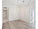 Dining room with modern flooring, decorative hanging light fixture and view into hallway and front door at 3332 Mcmath Dr, Palm Harbor, FL 34684