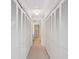 Hallway with multiple, slatted closet doors and access to bathroom at 3332 Mcmath Dr, Palm Harbor, FL 34684
