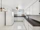 Bright kitchen with white cabinetry, tile flooring, and modern appliances creating a clean, functional space at 3332 Mcmath Dr, Palm Harbor, FL 34684