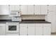 Close-up showcases the kitchen's pristine white cabinetry, built-in microwave, and sleek countertops at 3332 Mcmath Dr, Palm Harbor, FL 34684