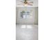 Bright living room with a ceiling fan, large windows, and light-colored tile flooring at 3332 Mcmath Dr, Palm Harbor, FL 34684