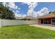 Fenced backyard with a grassy lawn and white vinyl fence at 2711 Coldstone Ln, Holiday, FL 34691