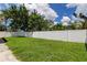 Private backyard with grassy lawn and white vinyl fence at 2711 Coldstone Ln, Holiday, FL 34691