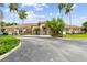 Community clubhouse with palm trees and landscaping at 2711 Coldstone Ln, Holiday, FL 34691