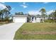 Single-story house with grey exterior, white garage, and a well-maintained lawn at 9333 Hialeah Ter, Port Charlotte, FL 33981