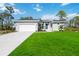 Newly built home with a white garage door and a lush green lawn at 9333 Hialeah Ter, Port Charlotte, FL 33981