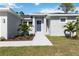 Modern front entrance with a blue door and palm trees at 9333 Hialeah Ter, Port Charlotte, FL 33981