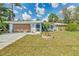 Charming single-story home featuring a stone accent wall, wood garage door, and well-manicured front yard at 20176 Tralee Dr, Port Charlotte, FL 33952