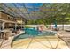 Large, screened pool area with a rock waterfall feature, swim-up bar, and spa at 601 Seven Oaks Ct, Brooksville, FL 34601