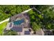 Aerial view of a house with solar panels and a screened-in pool at 601 Seven Oaks Ct, Brooksville, FL 34601