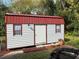 White and red metal shed with two windows at 1026 Roosevelt Ave, Spring Hill, FL 34604