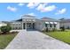 Modern two-story home with a paver driveway and landscaping at 8874 Players Dr, Weeki Wachee, FL 34613