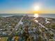 Aerial view of a waterfront community with canal access and a sunset view on the horizon at 13912 Sommers Ave, Hudson, FL 34667