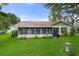 Home features a screened porch, lush lawn, and bird bath at 2241 Merion Ct, Spring Hill, FL 34606