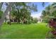 Large backyard with lush grass and mature trees at 2241 Merion Ct, Spring Hill, FL 34606
