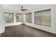Spacious common area with wood-look flooring, large windows, and ceiling fan at 2241 Merion Ct, Spring Hill, FL 34606