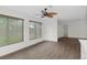 Spacious common area with wood-look flooring, large windows, and ceiling fan at 2241 Merion Ct, Spring Hill, FL 34606