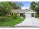 House exterior featuring a two-car garage and lush landscaping at 2241 Merion Ct, Spring Hill, FL 34606