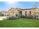 Tan house with red shutters, two-car garage, and landscaped lawn at 12931 Conquistador Loop, Spring Hill, FL 34610