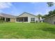 Large backyard with lush lawn and screened patio at 11724 Heritage Point Dr, Hudson, FL 34667