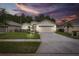 Tan one-story house with a two-car garage and manicured lawn at 1153 Dustan Pl, Trinity, FL 34655