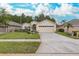 Tan one-story house with a two-car garage and manicured lawn at 1153 Dustan Pl, Trinity, FL 34655