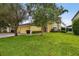 House exterior showcasing a three-car garage and lush green landscaping at 1545 Regal Mist Loop, Trinity, FL 34655