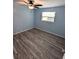 Light blue bedroom featuring grey wood-look flooring at 27299 Azen Loop, Brooksville, FL 34602